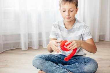 Renkli stres önleyici hareketler çocuklar için pop tüpü oyuncakları itiyor. Çocukların elinde esnek kıvrımlı boru. Duyusal oyuncaklarla oynayan çocuk. Hayal gücünü geliştirmek ve motor becerilerini geliştirmek için eğlenceli oyun..