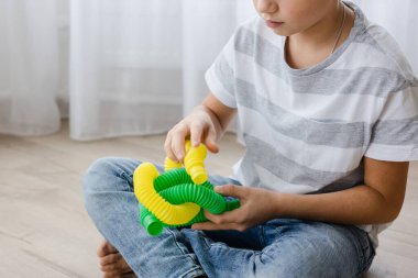 Renkli stres önleyici hareketler çocuklar için pop tüpü oyuncakları itiyor. Çocukların elinde esnek kıvrımlı boru. Duyusal oyuncaklarla oynayan çocuk. Hayal gücünü geliştirmek ve motor becerilerini geliştirmek için eğlenceli oyun..
