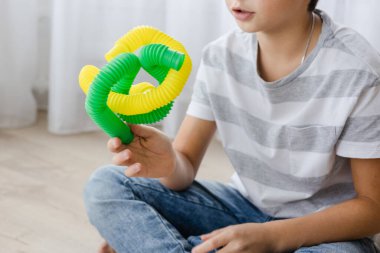 Renkli stres önleyici hareketler çocuklar için pop tüpü oyuncakları itiyor. Çocukların elinde esnek kıvrımlı boru. Duyusal oyuncaklarla oynayan çocuk. Hayal gücünü geliştirmek ve motor becerilerini geliştirmek için eğlenceli oyun..