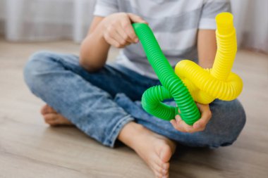 Renkli stres önleyici hareketler çocuklar için pop tüpü oyuncakları itiyor. Çocukların elinde esnek kıvrımlı boru. Duyusal oyuncaklarla oynayan çocuk. Hayal gücünü geliştirmek ve motor becerilerini geliştirmek için eğlenceli oyun..