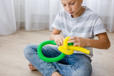 Renkli stres önleyici hareketler çocuklar için pop tüpü oyuncakları itiyor. Çocukların elinde esnek kıvrımlı boru. Duyusal oyuncaklarla oynayan çocuk. Hayal gücünü geliştirmek ve motor becerilerini geliştirmek için eğlenceli oyun..