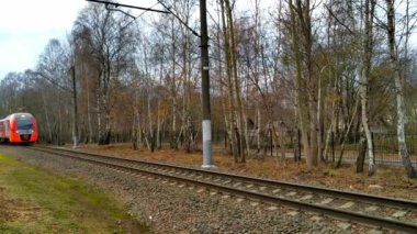 Gri ve kırmızı bir tren geçiyor.