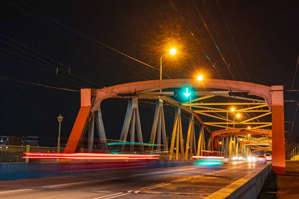 Orange road bridge with reverse traffic, night photo