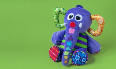 Yumuşak oyuncak fil yeşil arka planda kalır.