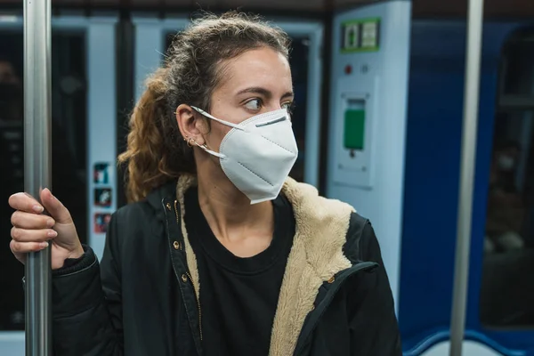Yeni normal. Metroda yürüyen genç bir kız. Metroda yürüyen genç kız. Covid 'e karşı maske. Yüz maskeli bir genç. Salgın. Metroyu kullanan genç bir kız. Metroya binen bir genç.
