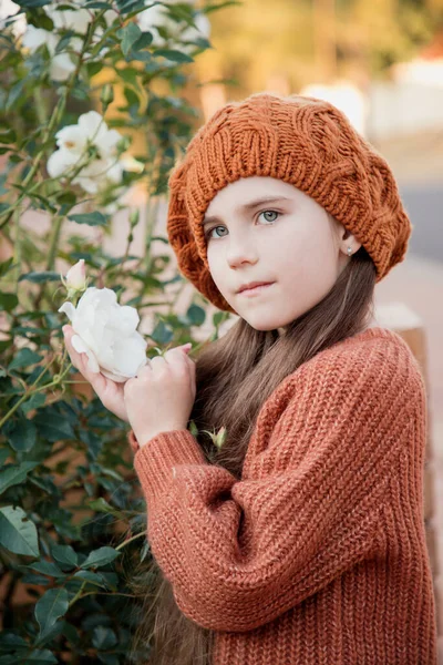 茶色のベレー帽の美しい少女の肖像画とバラの茂みの近くに長い髪のセーター 秋の気分 フランス語が少ない モデル 南アフリカの冬 — ストック写真