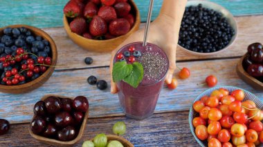 El, ahşap masaya bir bardak chia tohumu koyar. Vejetaryen kahvaltısı.