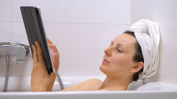 Young Woman Using Tablet Pc In Bathtub
