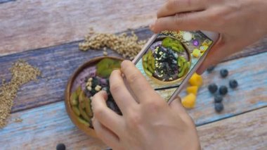 Kadın Elleri Ahşap Masa Üzerinde Sağlıklı Smoothie Bowl Fotoğrafı Çekiyor. 