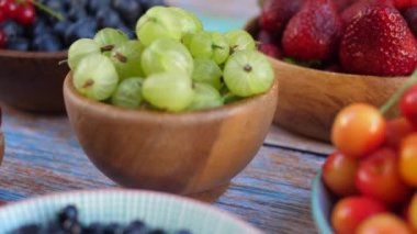 Mevsimlik yaz meyvelerinin karışımı masada. Bektaşi üzümü, kiraz, kiraz, çilek, yabanmersini, frenk üzümü.