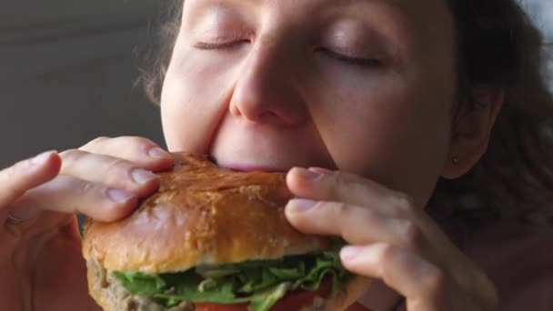 Retrato de una mujer joven comiendo sándwich vegano o hamburguesa — Vídeo de stock