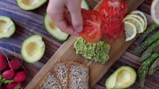 Zdrowy wegańskie śniadanie Concept. Toast awokado z cytryną i pomidorem. — Wideo stockowe