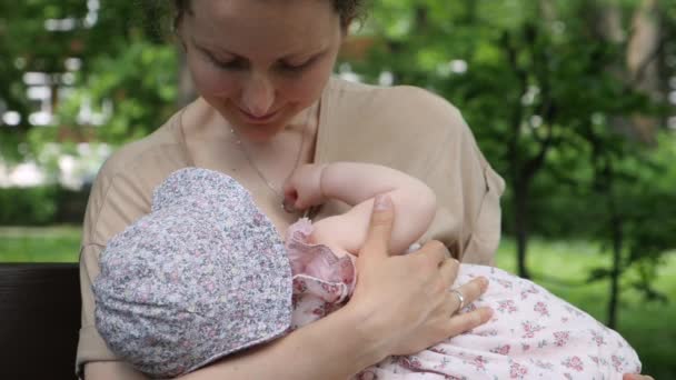 Borstvoeding geven op een openbare plaats. Moeder borstvoeding haar baby in park — Stockvideo