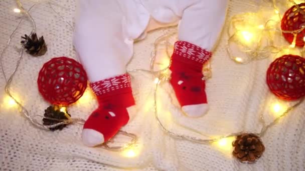 Pies de bebé en divertidos calcetines de Navidad. Felices Fiestas y Feliz Año Nuevo. — Vídeos de Stock