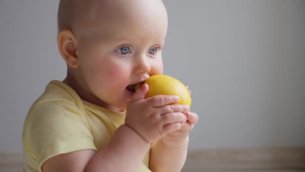 Bébé drôle mignon jouer avec le citron. — Video