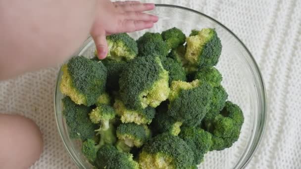 Bambino che gioca con una grande ciotola di broccoli. — Video Stock