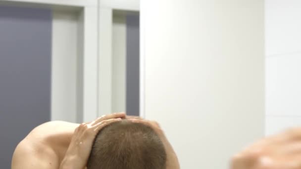Молодой мужчина без рубашки умывается в ванной — стоковое видео