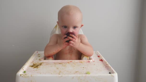 Carino neonata sporcato nel cibo mentre mangiare prugna. — Video Stock