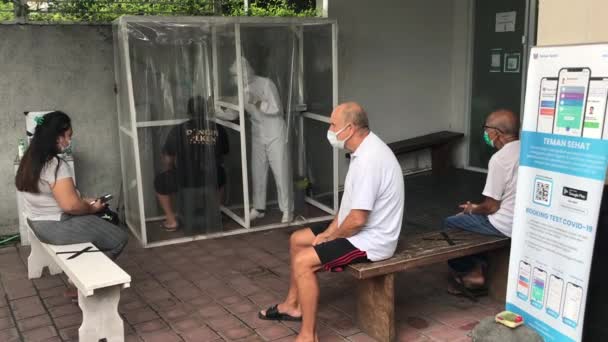 Personas con máscaras en la cara esperando para hacerse una prueba rápida de coronavirus. Bali-Indonesia-2021 — Vídeo de stock
