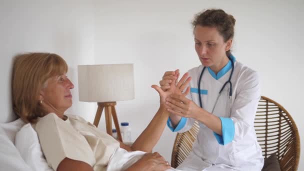 Médico médico privado examinando las articulaciones y los huesos de los pacientes mano, la comprobación de la artritis durante la visita domiciliaria — Vídeo de stock
