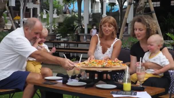 Heureuse famille multi-générations de grands-parents, jumeaux et jeune maman déjeunant. Pizza party — Video