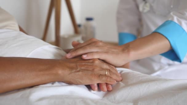 La trabajadora de salud pone su mano en la mano de los pacientes. Primer plano. — Vídeos de Stock