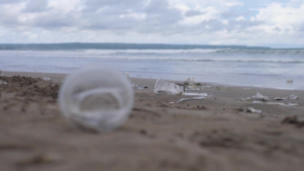 Крупним планом пластикова чашка залишилася на пляжі. Багато іншого на тлі . — стокове відео