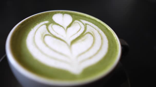 Вид зверху ложка перемішуючи мачу зеленого чаю латте з латексним серцевим мистецтвом — стокове відео