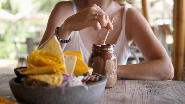 Mooie jonge blonde vrouw geniet van haar chocolade milkshake terwijl ze alleen luncht in een strandrestaurant. Soloreizen — Stockfoto