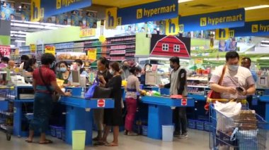 Maskeli insanlar süpermarketteki tezgahların alışverişini ödüyorlar. Covid-19 salgını sırasında alışveriş. Aralık - 2020 - Bali
