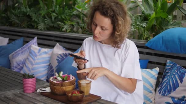 食物下垂的概念。白色女性食物博客与她的追随者在社交媒体上分享她所订购的食物 — 图库视频影像