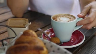 İçmek için bir fincan cappuccino seçerken elinizi kapayın. Yanında da ücretsiz kurabiyeyle servis edilen kahve.. 