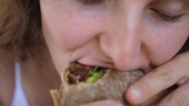 Aç dişinin ağzını kapat. Sandviçten bir ısırık al ve büyük bir iştahla çiğne. 