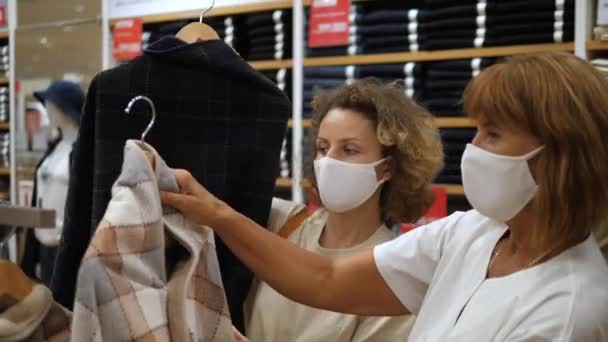 Nieuw leven na pensionering. Jonge styliste plukken outfits voor een nieuwe garderobe van een dame van middelbare leeftijd tijdens covid-19 — Stockvideo