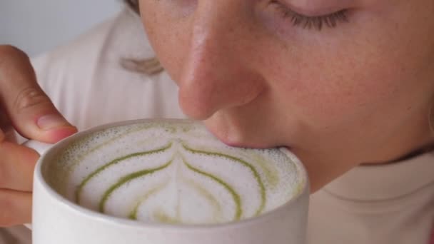 Widok z góry dziewczyny biorąc łyk jej matcha latte i cieszy się nim — Wideo stockowe