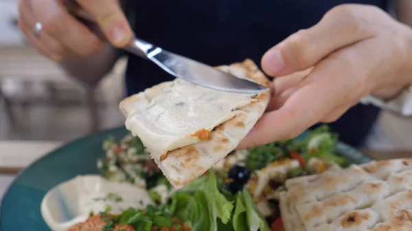 Pita 'ya el sallayan humus. Salata, sos ve pide ile ezme tabağı. Sağlıklı organik Orta Doğu mutfağı. 