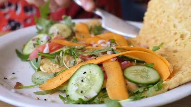 As mãos femininas que cortam uma omeleta com verduras. Café da manhã orgânico saudável servido em prato branco. Conceito de estilo de vida saudável. — Vídeo de Stock