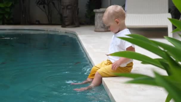 Niedliches kaukasisches Baby, das mit ihnen am Pool spielt. Glückliche Tage in der Villa — Stockvideo