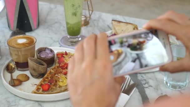 Ruce fotí zdravé veganské snídaně vaflí, ovoce a kávy. Zdravý rostlinný životní styl — Stock video