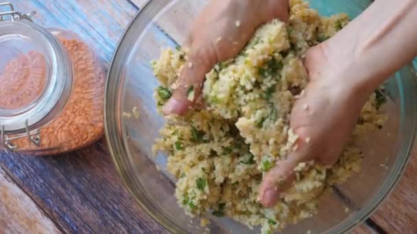 Mãos misturando ingredientes para panquecas vegan em uma tigela. Jarro com lentilhas em uma mesa de madeira — Vídeo de Stock