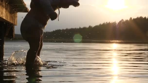Szczęśliwe niemowlęta małe nóżki żartobliwie pluskające wodą z jeziora. Rodzinne wakacje nad jeziorem — Wideo stockowe
