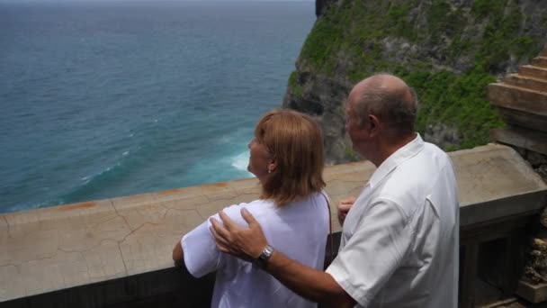 Esküvői évforduló koncepció. Középkorú pár, akik felfedezik az óceán szépségét — Stock videók