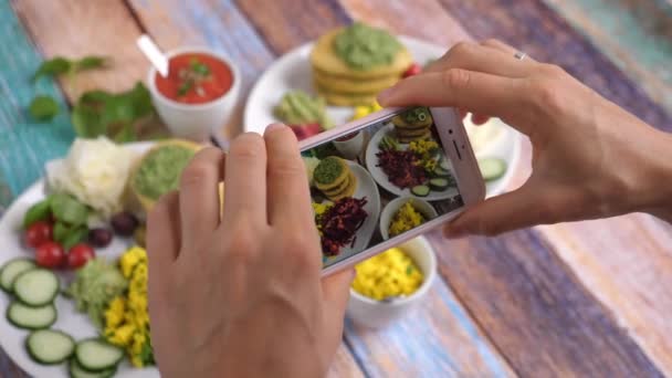 Akıllı telefonla sağlıklı organik vejetaryen kahvaltısının fotoğrafını çeken eller.. — Stok video