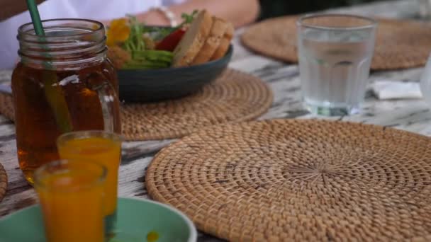 Pessoa que serve hambúrguer vegan sem carne com batatas doces em um lado em um placemat tecido. — Vídeo de Stock