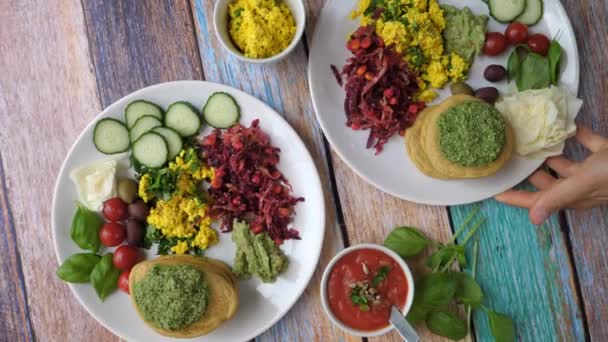 Mani che servono piatto con sana colazione vegana biologica con tofu scramble, frittelle e verdure. Stile di vita sano concetto. — Video Stock