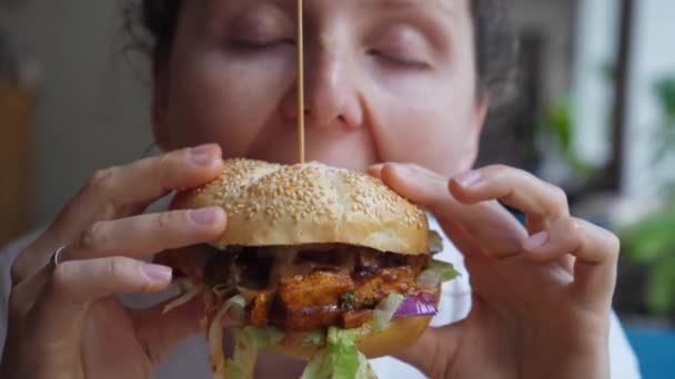 Κορίτσι τρώει νόστιμα βιολογικά vegan burger. Κλείσιμο στόματος. — Αρχείο Βίντεο