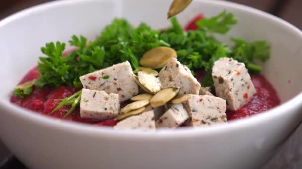 Pompoenpitten toevoegen aan veganistische romige soep met tofu. — Stockvideo