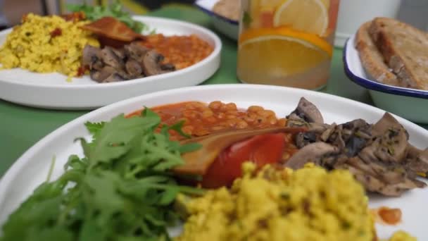 Veganes englisches Frühstück auf weißem Teller in einem Café. Tofu-Rührei, Bohnen veganer Speck. Gesunder Lebensstil — Stockvideo