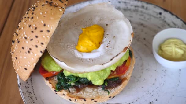 Vista dall'alto dell'hamburger vegano con uova alternative a base vegetale servite in cima. Stile di vita vegano sano — Video Stock