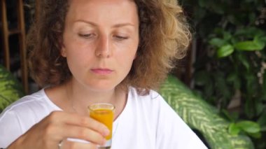 Genç beyaz kadın sağlıklı zerdeçal iğnesi deniyor ve merakla bakıyor. 